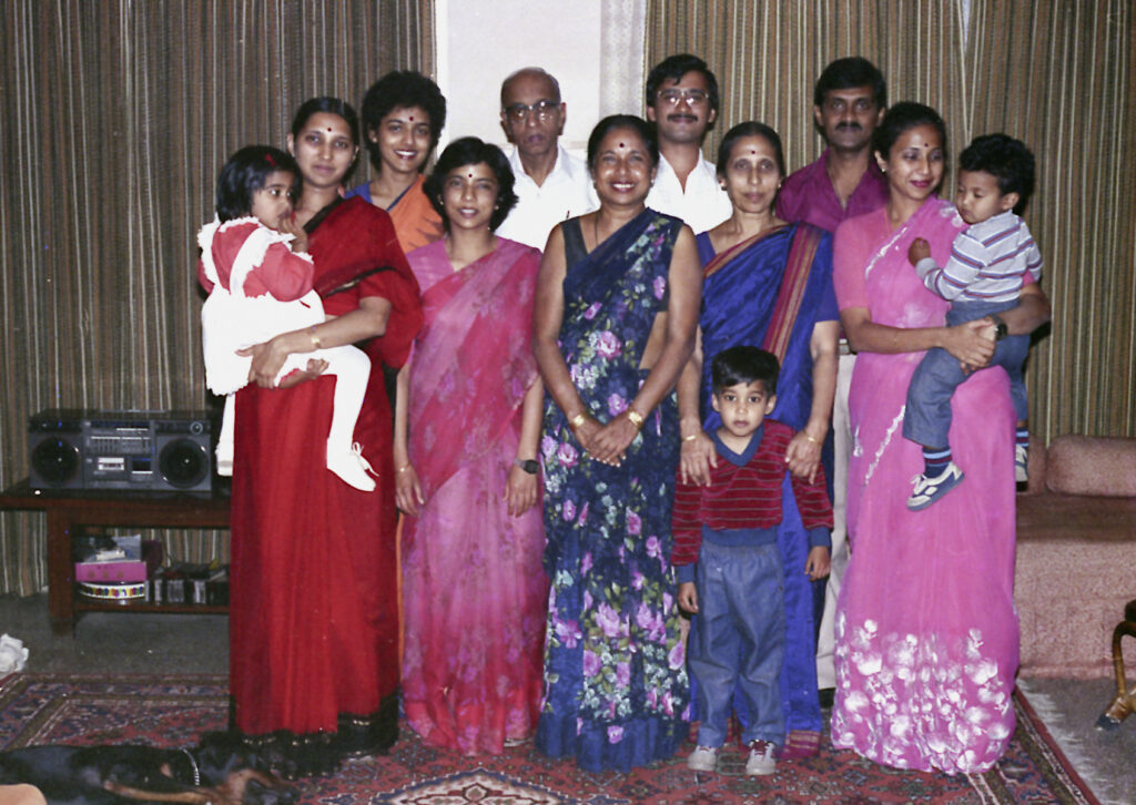 Three generations of women in a family portrait wearing traditional sarees, 1987